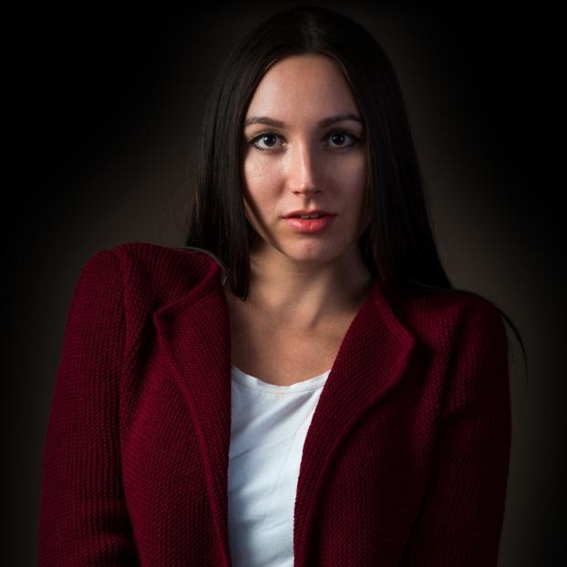 Studio headshot portrait of a woman in a maroon jacket