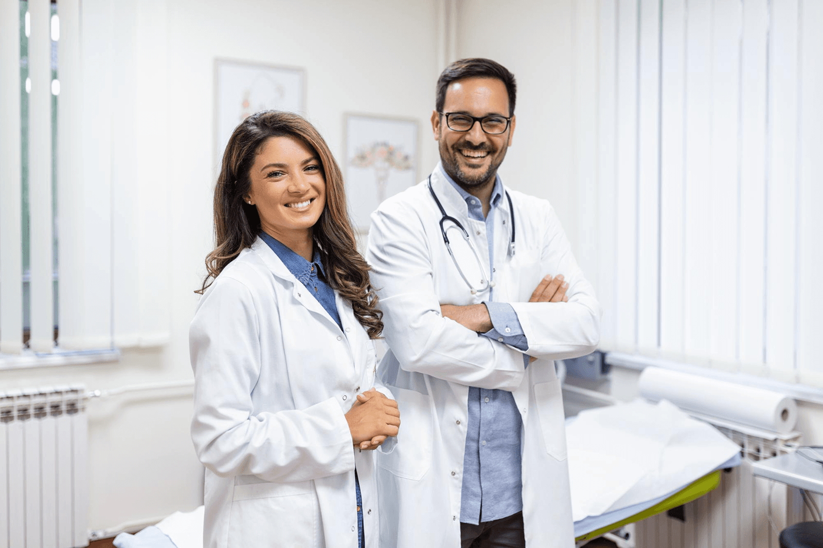 Photo of two smiling doctors in white coats in a medical office